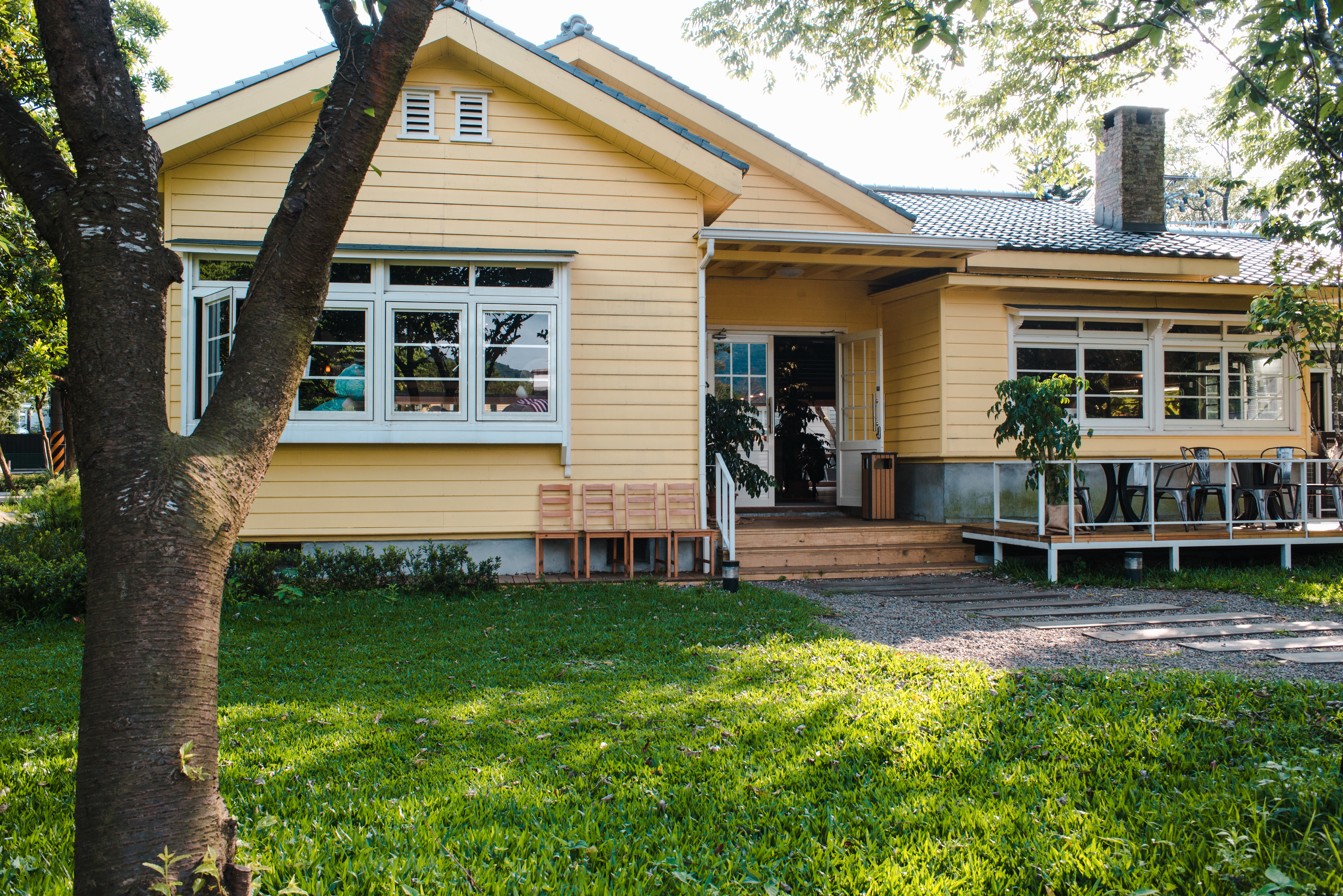 charming-yellow-house-with-wooden-windows-green-grassy-garden